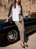 Dress pants for women in a tailored taupe fabric, styled with a crisp white shirt and pointed flats.