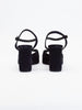 Black heels for women with thick block heels, ankle straps, and suede finish shown from the back view.