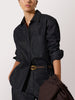 Denim shirt for women styled with matching dark wash jeans and a slim brown belt for a monochrome look.