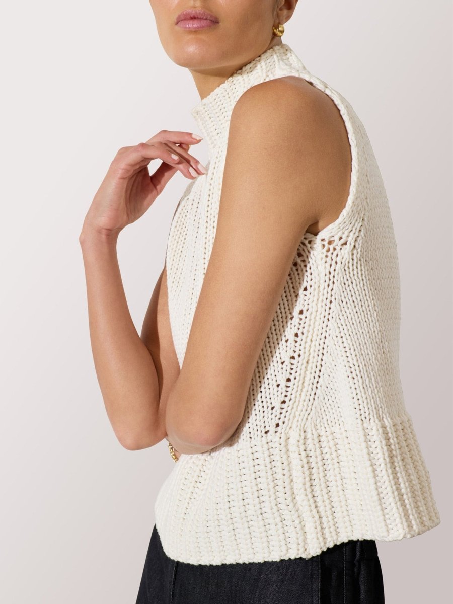 Women's knitted tank top in ivory with a high neckline and textured ribbed hem detail.