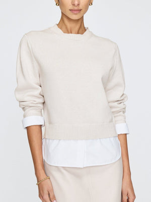 Women’s white crewneck sweater with long sleeves and relaxed fit, styled casually