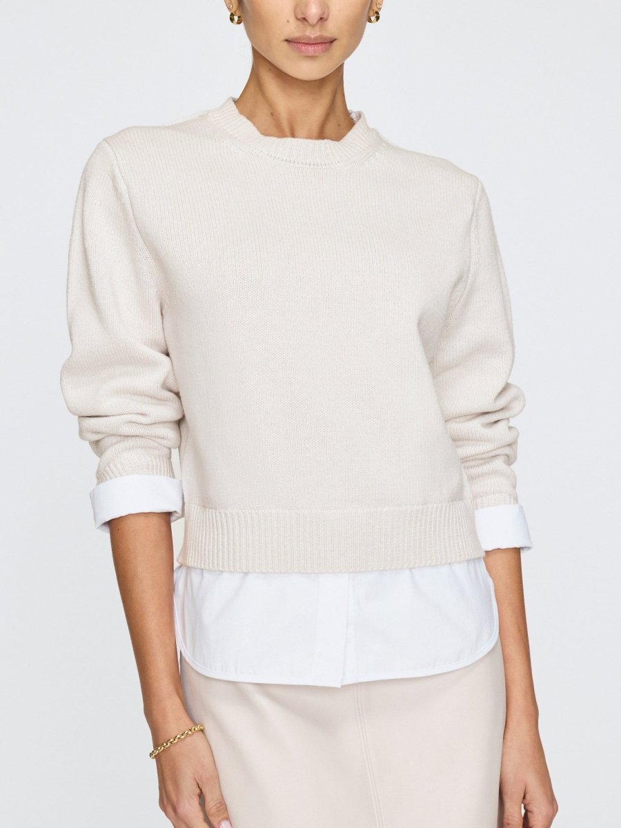 Women’s white crewneck sweater with long sleeves and relaxed fit, styled casually