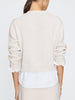 Long sleeve crewneck sweater for women in soft neutral knit, styled over a white shirt.