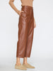 Brown vegan leather pants for women featuring structured seams and cropped length, styled with a ribbed camel sweater.