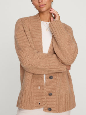 Camel cardigan for women featuring chunky knit, deep V-neckline, and large dark buttons styled over a white top.