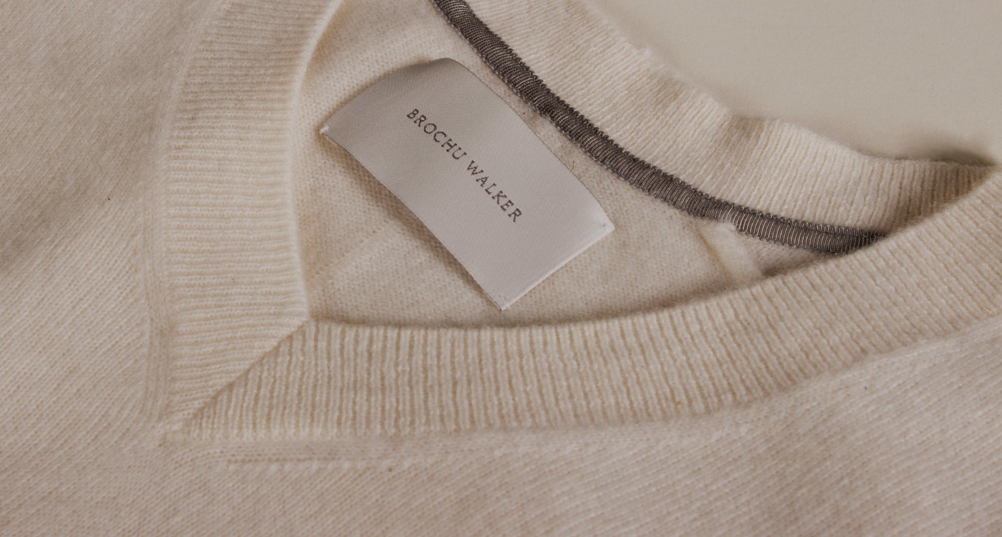 brochu walker tag on an off white sweater