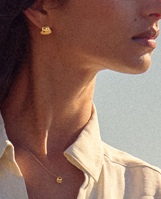 brochu's fine jewelry tops and pendant in 18k gold on a model