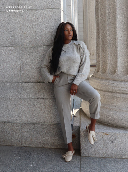 Neutral-toned outfit with tailored gray pants and a soft knit sweater, complemented by cream loafers for a sophisticated, city-chic aesthetic.